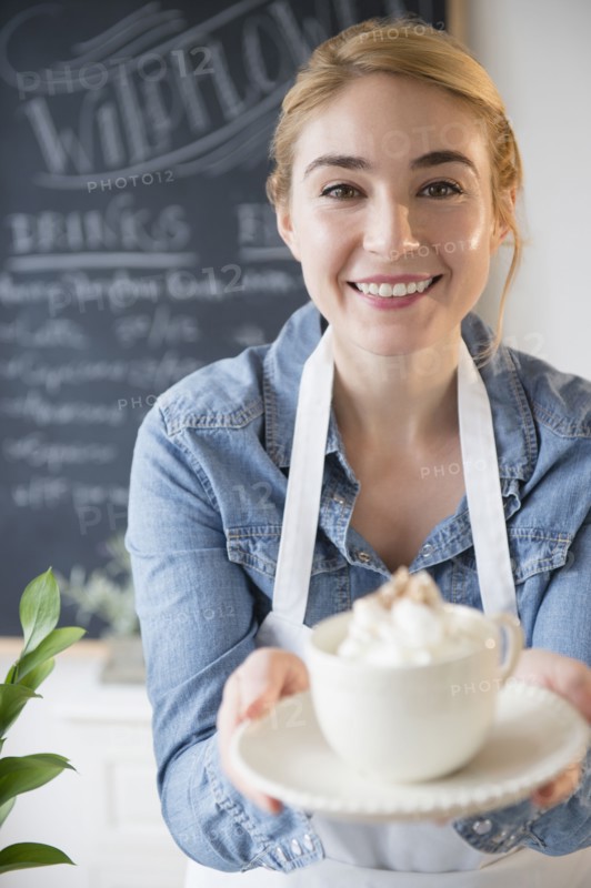 Caucasian barista serving coffee drink in cafe