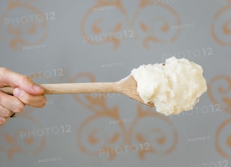 Close up of mashed potatoes on wooden spoon