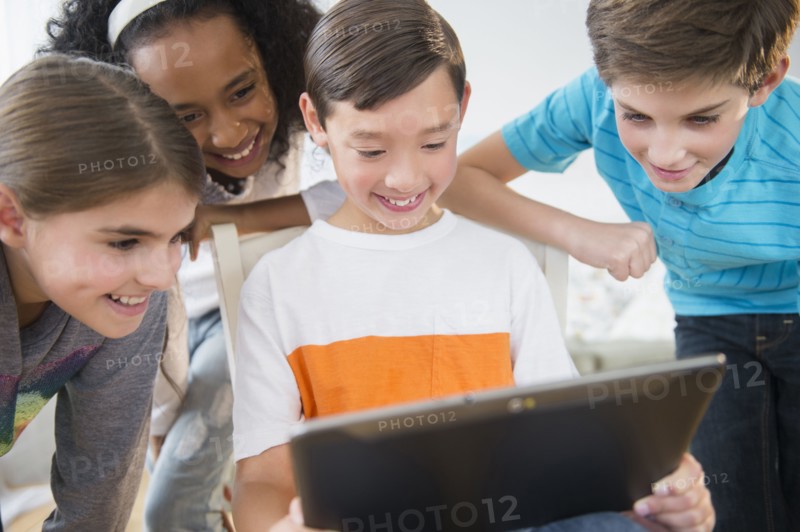 Smiling children using digital tablet