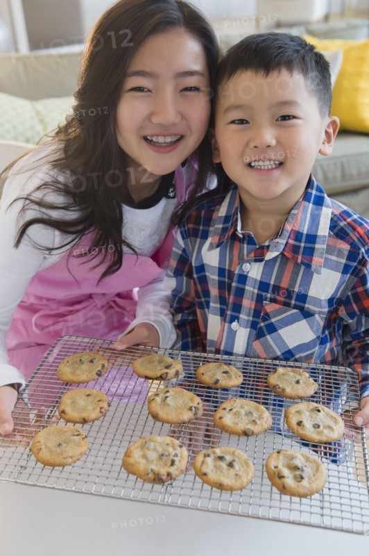 Asian brother and sister baking cookies