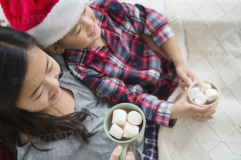 Asian brother and sister drinking hot cocoa at Christmas