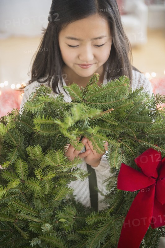 Asian girl carrying Christmas wreath