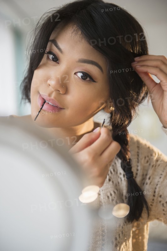Pacific Islander woman braiding her hair