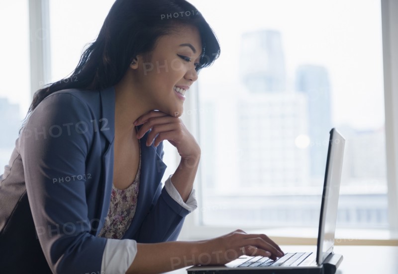 Pacific Islander businesswoman using laptop in office
