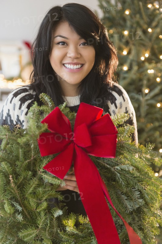 Pacific Islander woman holding Christmas wreath