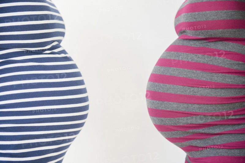 Close up midsection profiles of stomachs of pregnant women