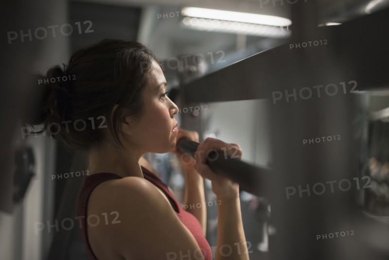 Mixed race woman using exercise machine in gym