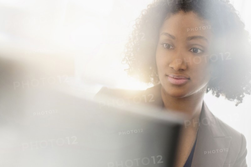 Mixed race businesswoman working at computer