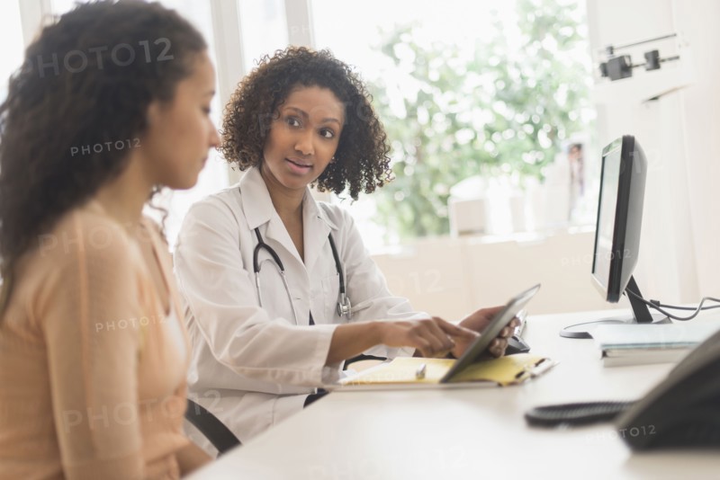 Doctor and patient using digital tablet in office