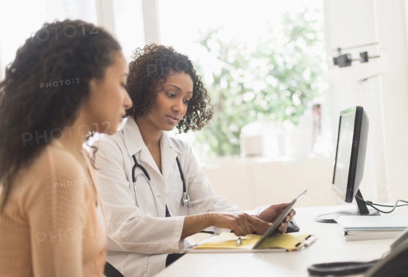 Doctor and patient using digital tablet in office