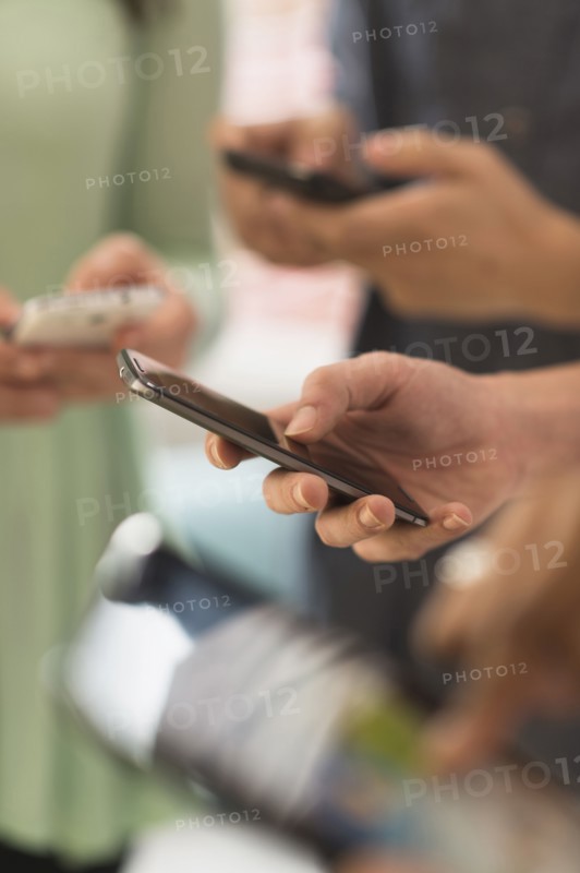Close up of hands of people texting with cell phones