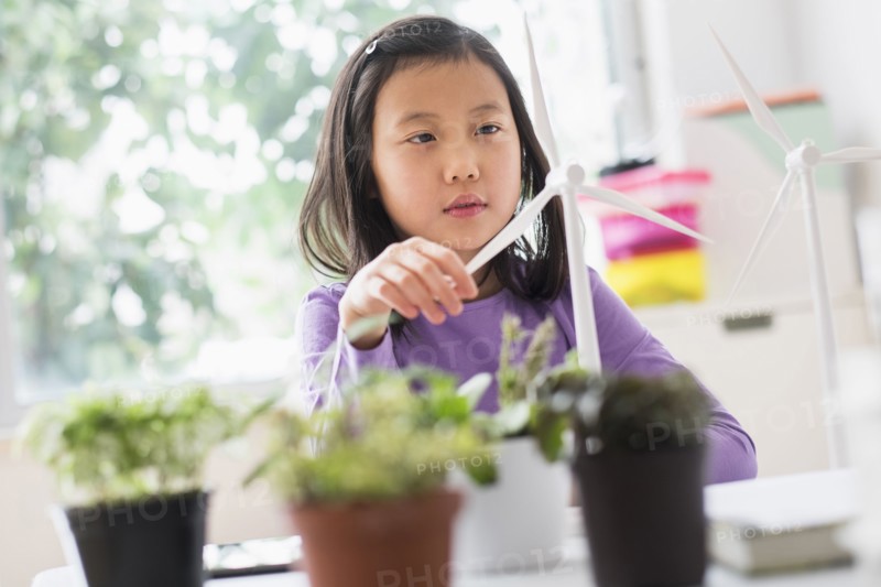 Chinese student examining model wind turbine in science lab