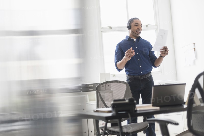 Black businessman talking on headset in office