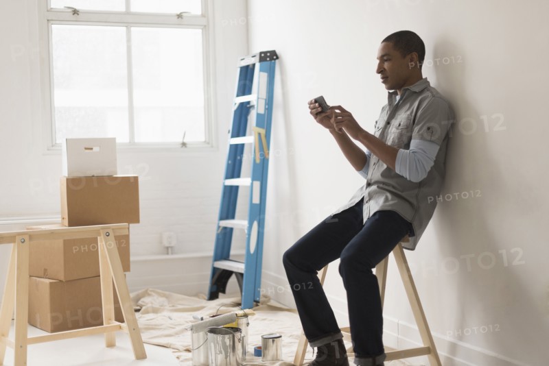 Black man sitting in room under renovation