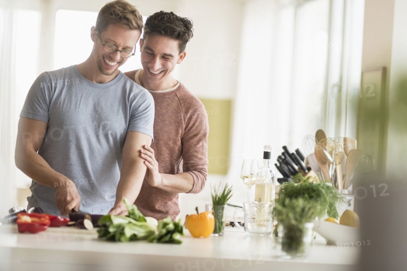 Caucasian gay couple cooking in kitchen