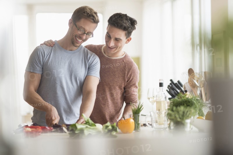 Caucasian gay couple cooking in kitchen
