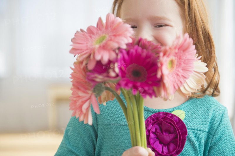 Caucasian girl holding bouquet of flowers