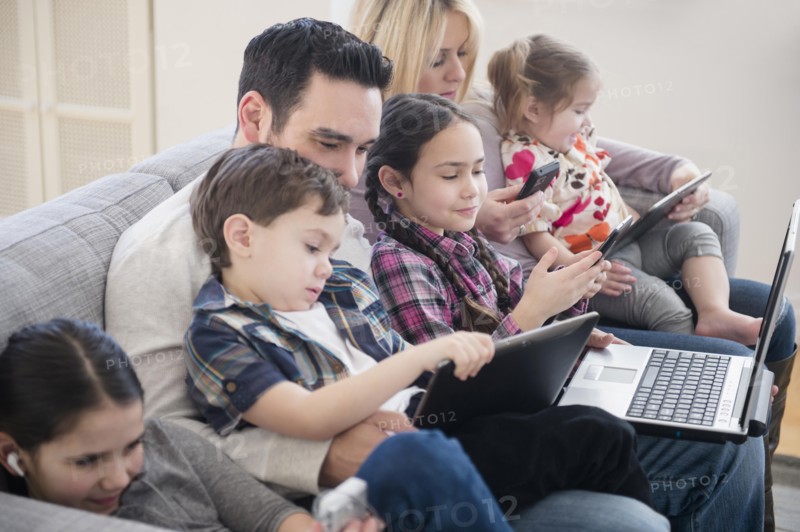 Caucasian family using technology on sofa
