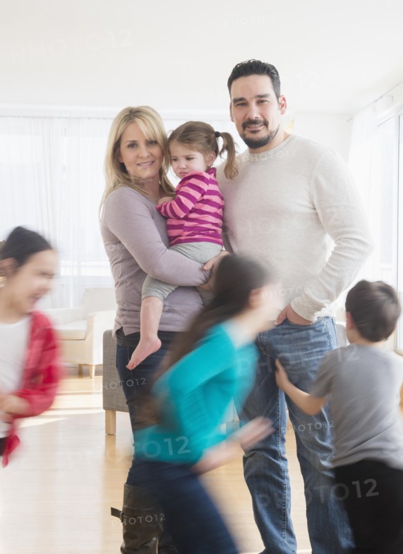Caucasian parents busy with running children