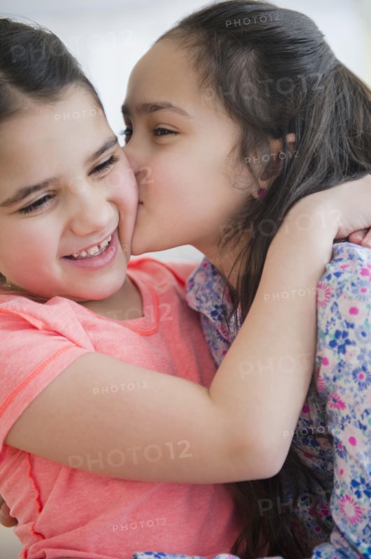 Close up of Caucasian sisters kissing