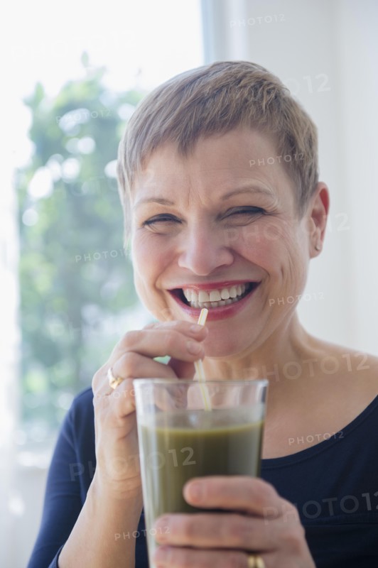 Caucasian woman drinking glass of healthy juice