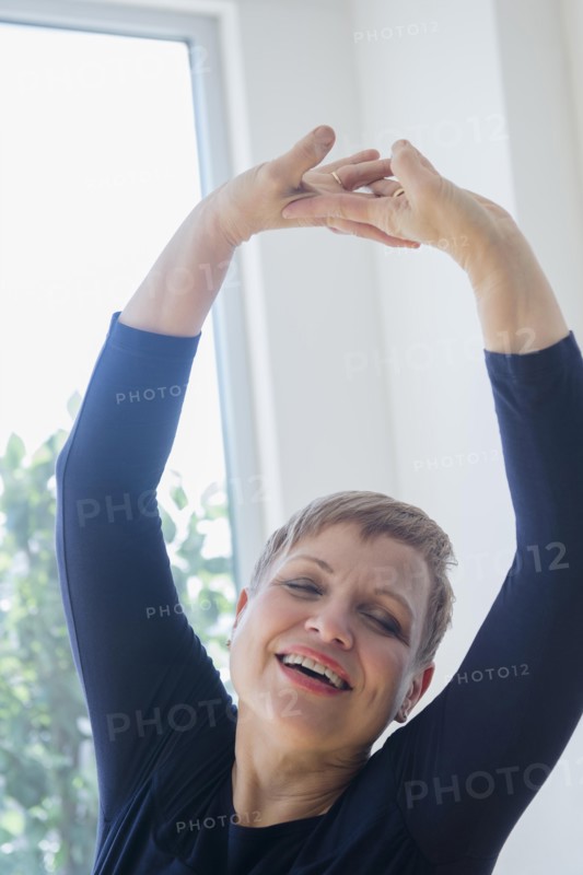 Caucasian woman stretching near window