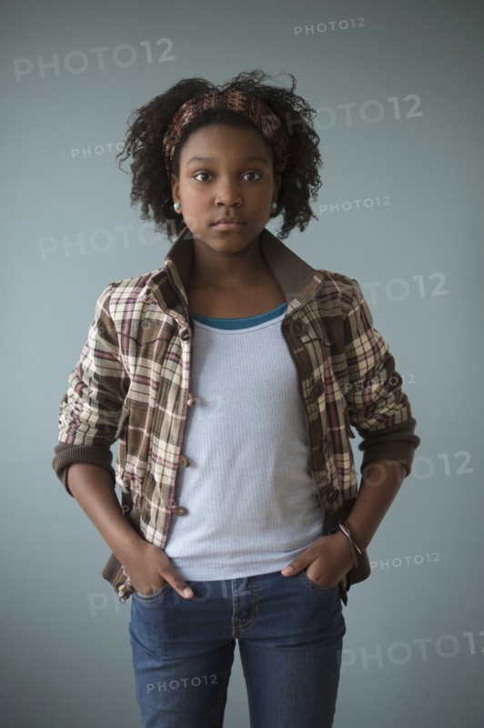 Stylish Black girl standing with hands in pockets