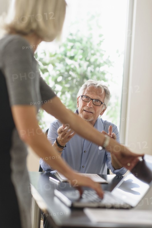 Older Caucasian business people arguing in office meeting