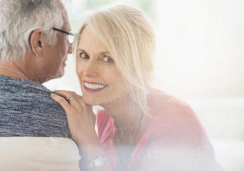 Close up of older Caucasian couple whispering