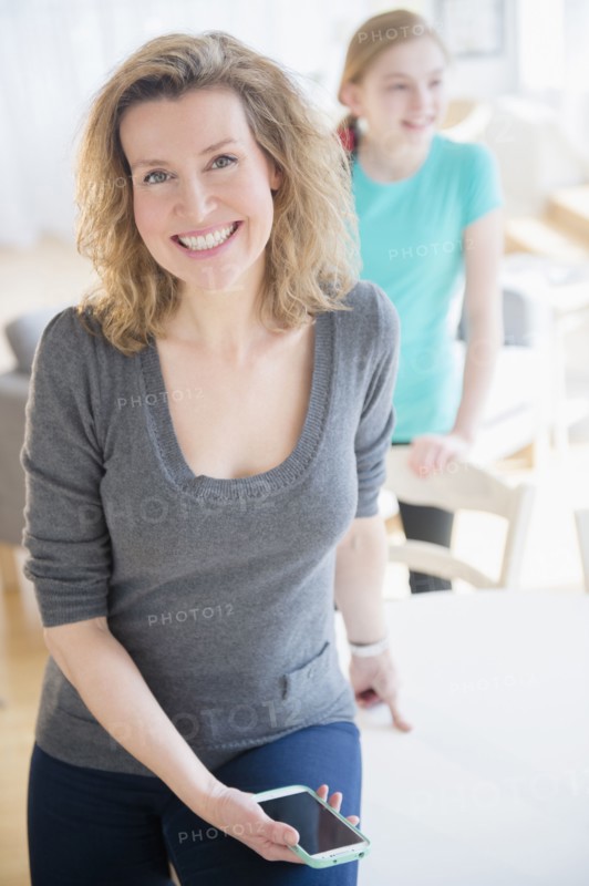 Caucasian woman holding cell phone in dining room