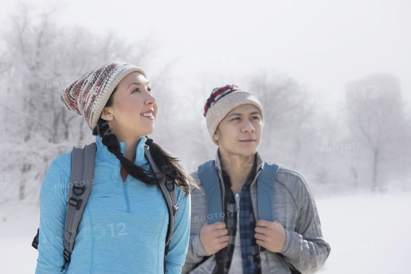 Couple hiking in snowy field