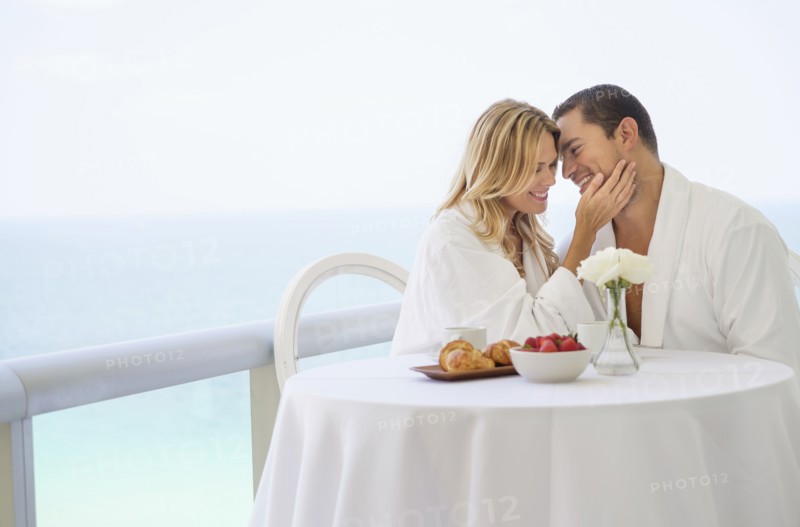 Couple eating breakfast on balcony