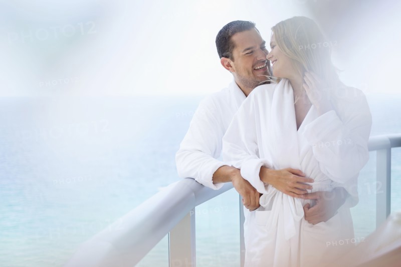 Couple hugging on balcony over ocean