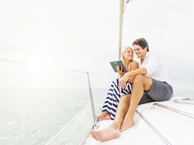 Couple using digital tablet boat deck