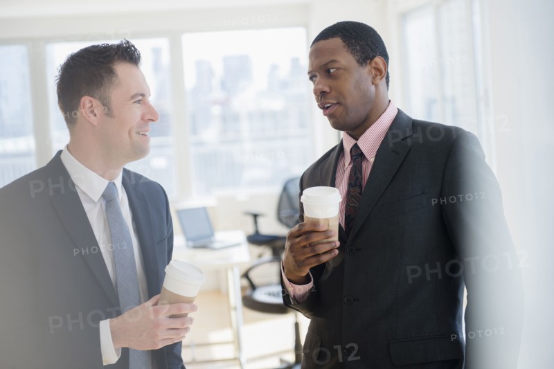Businessmen drinking coffee in office