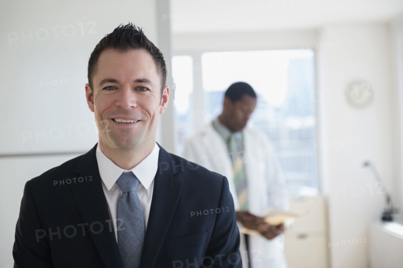 Businessman smiling in office with doctor