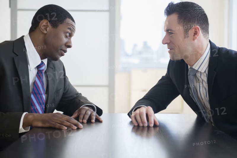 Businessmen talking in office meeting