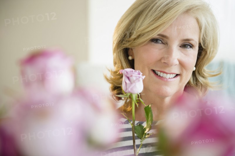 Caucasian woman holding pink rose