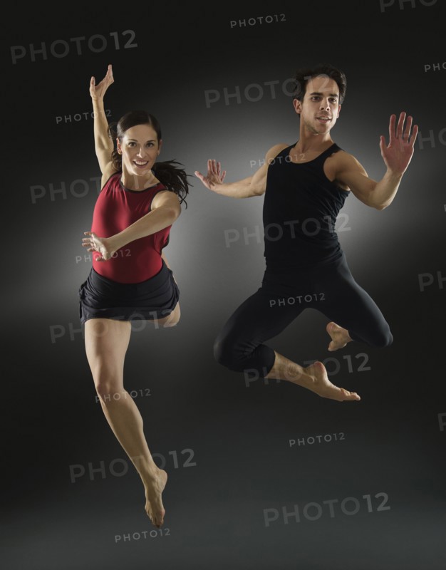 Hispanic dancers leaping in mid-air