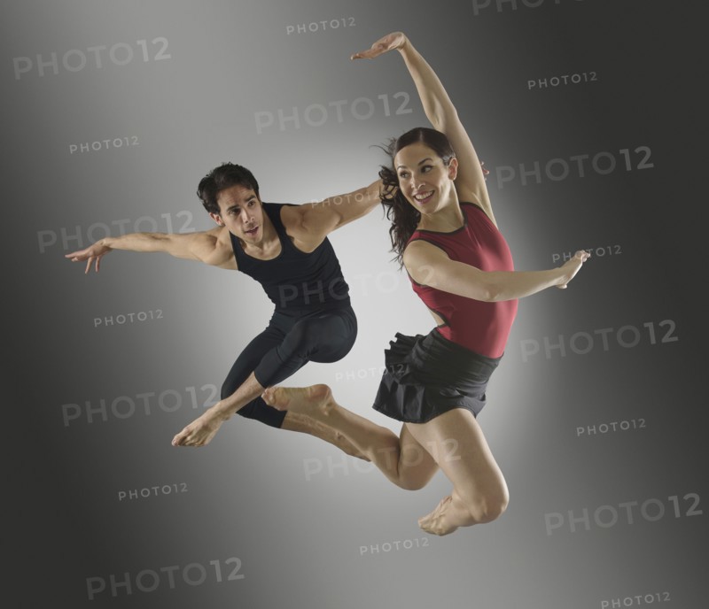 Hispanic dancers leaping in mid-air