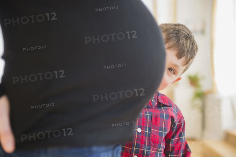 Boy admiring belly of pregnant mother