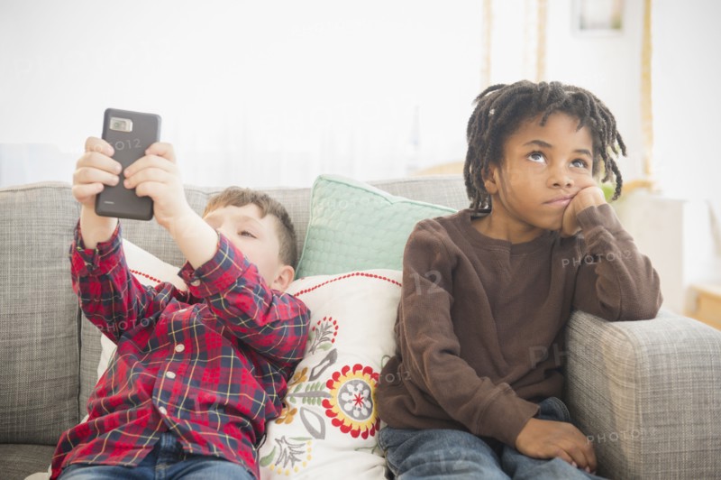Boy with cell phone ignoring friend
