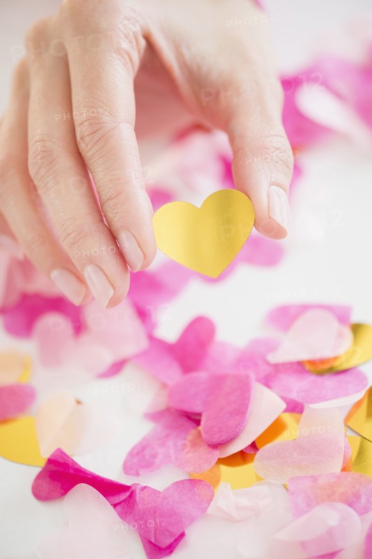 Mixed race woman holding confetti hearts