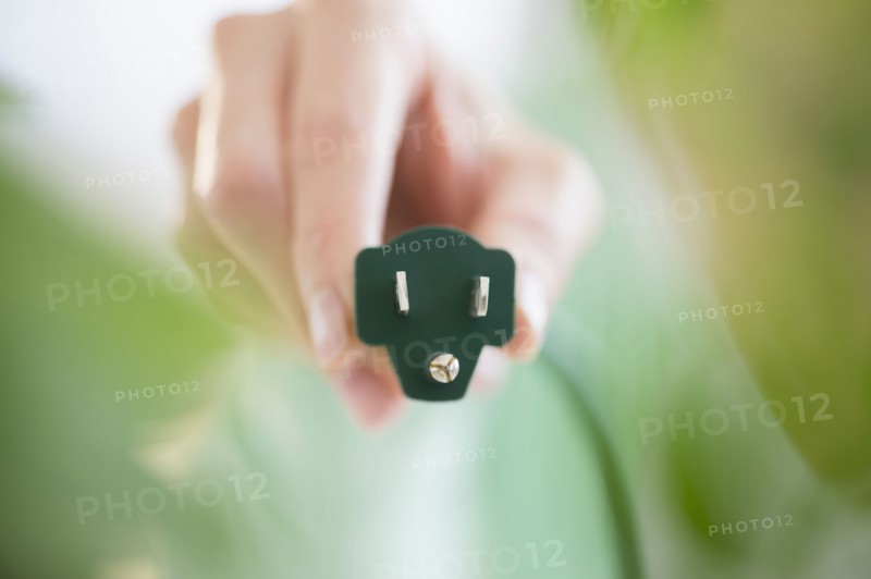 Mixed race woman holding electrical plug