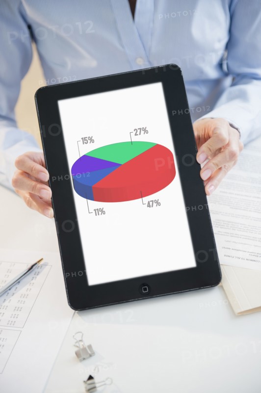 Mixed race businesswoman holding digital tablet with pie chart