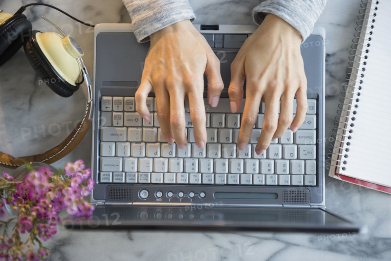 Mixed race woman using laptop at table