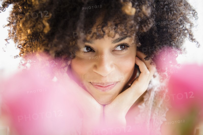 Mixed race woman resting chin in hands