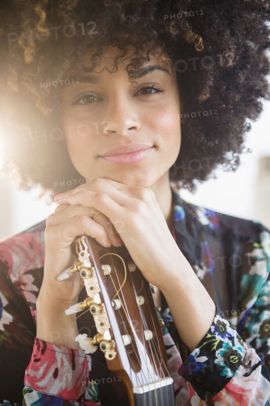 Mixed race musician holding guitar