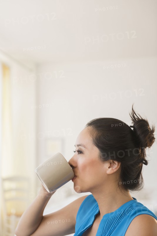 Chinese woman drinking cup of coffee