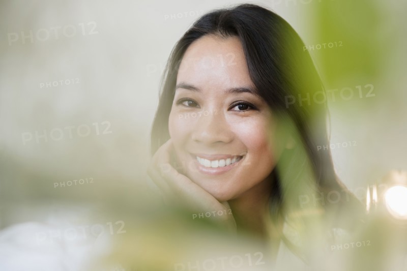 Chinese woman smiling with chin in hand